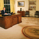 President Bush sits at his desk in the Oval Office, where he received messages from an intercom voice identifying itself as "God" and thought to have been Vice President Cheney (below).